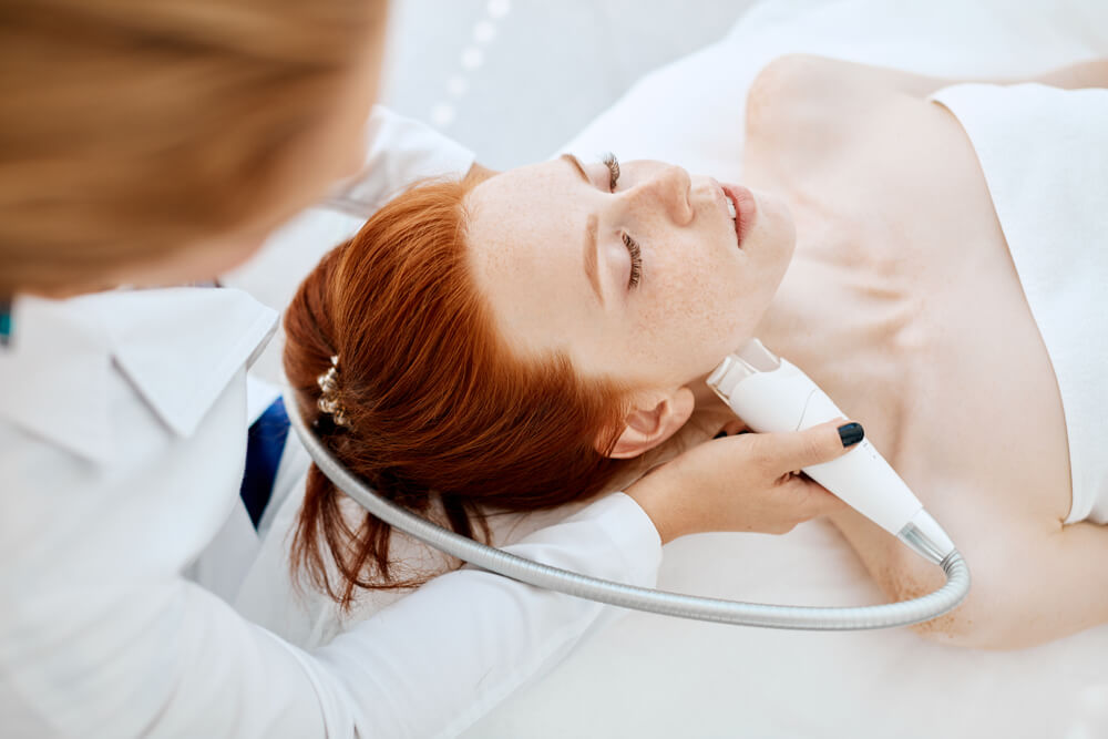 Woman receiving electric facial ultrusound peeling