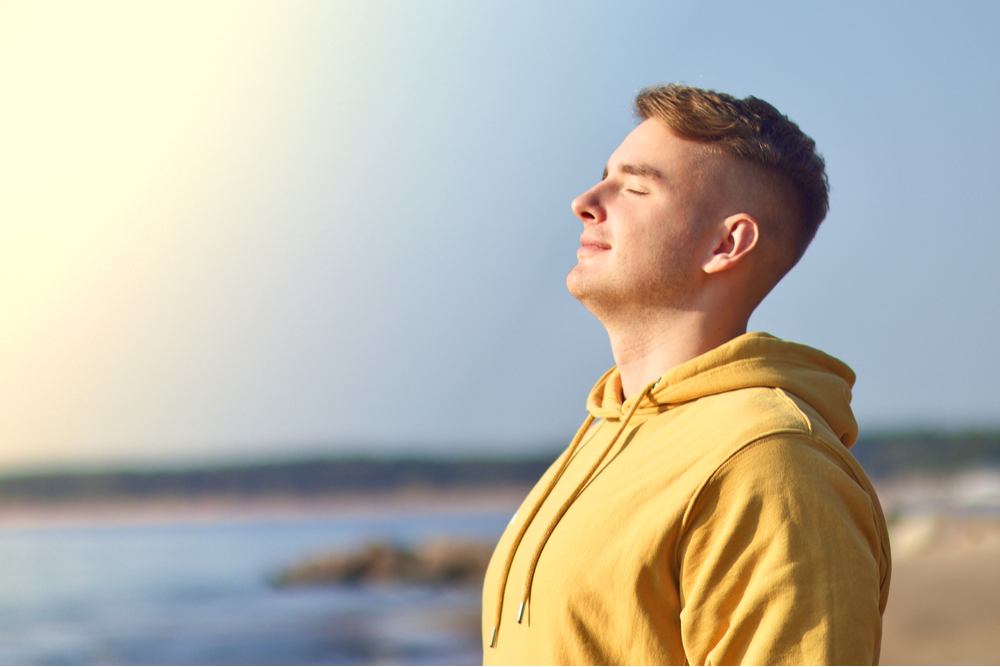 Young man enjoying good weather on the beach