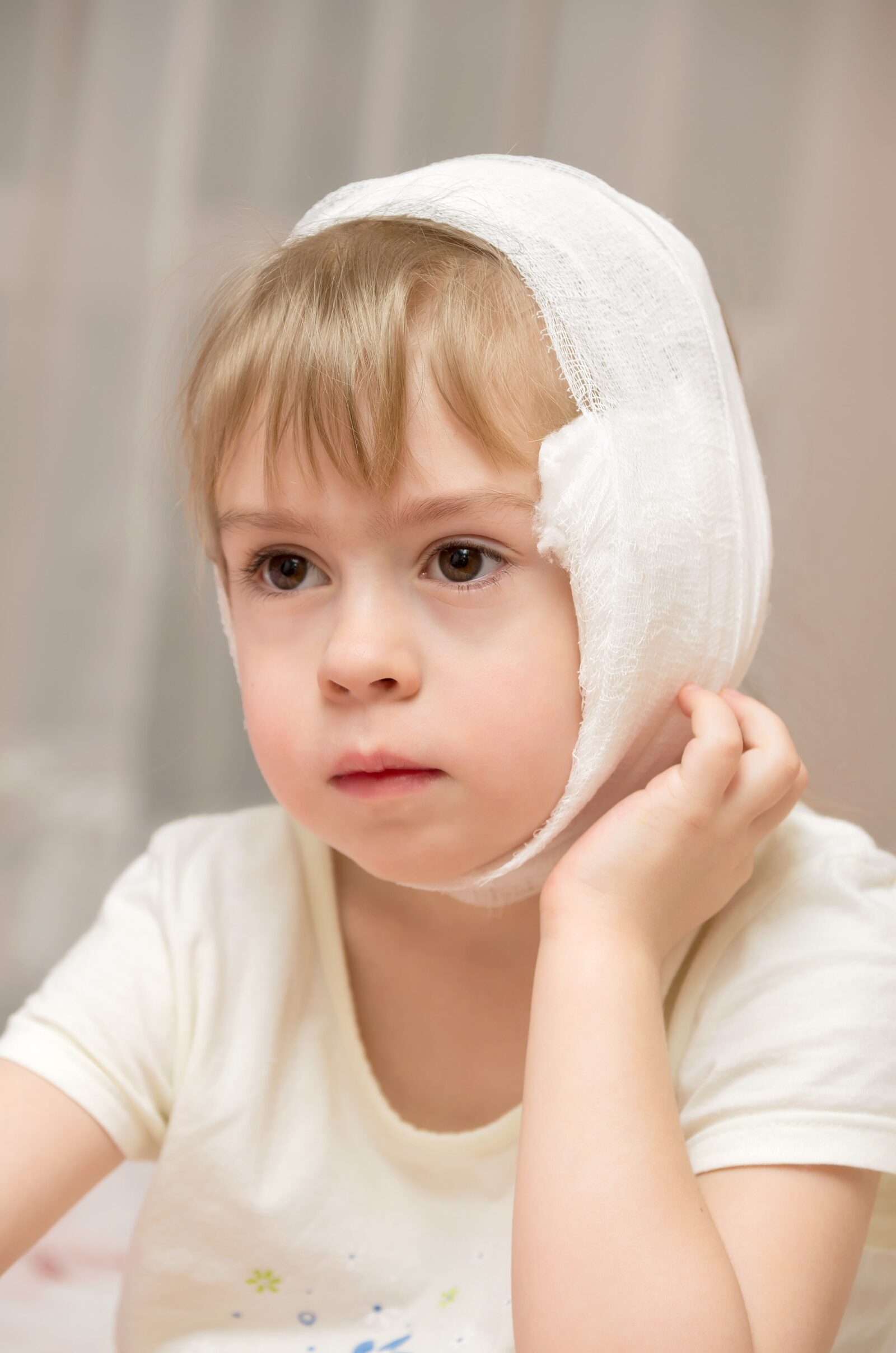 young child with ear bandage