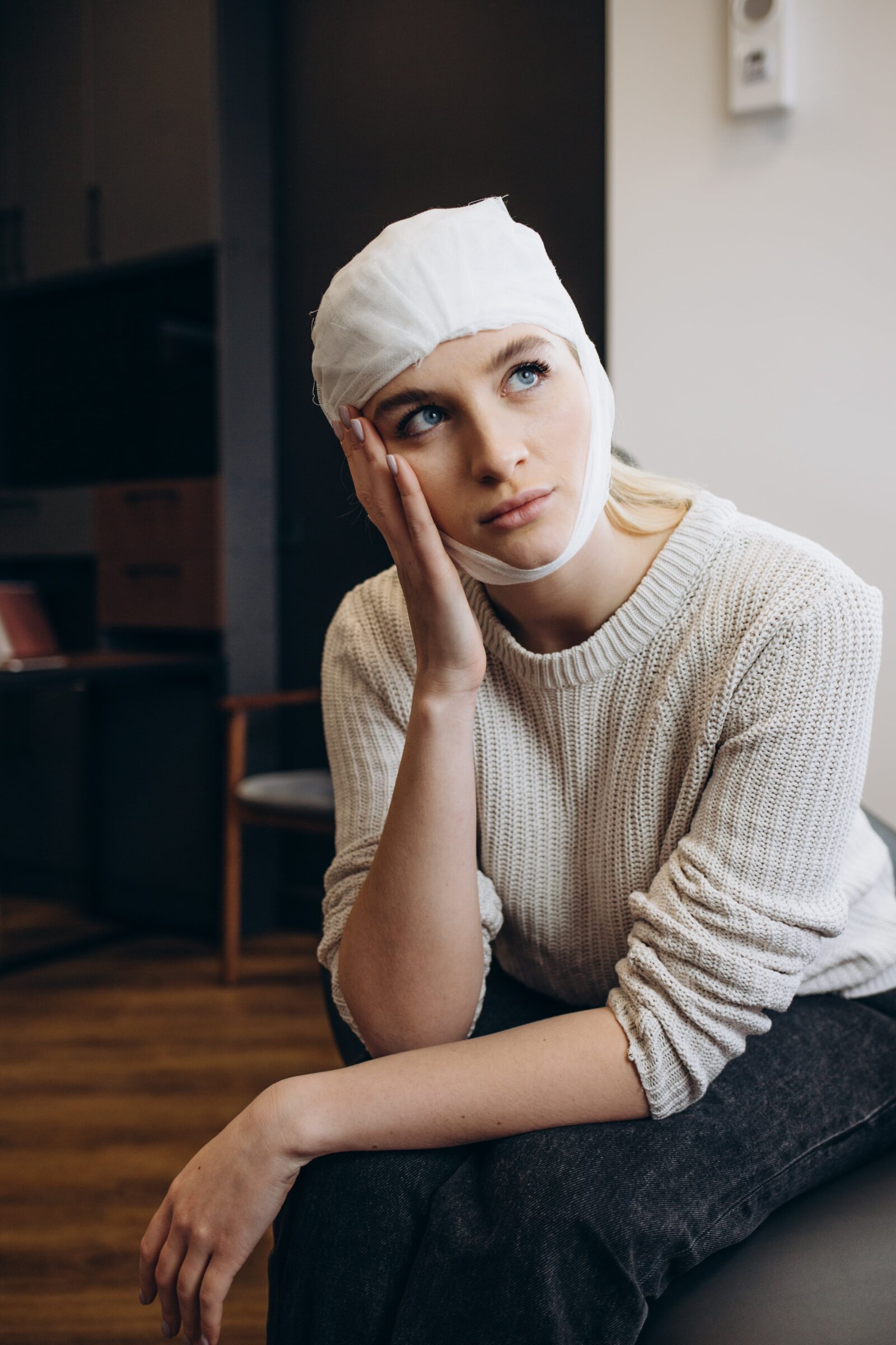 woman after facelift with bandage on her face