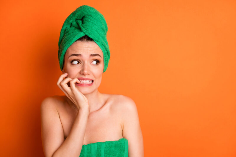 woman feeling worried while doing skin care routine