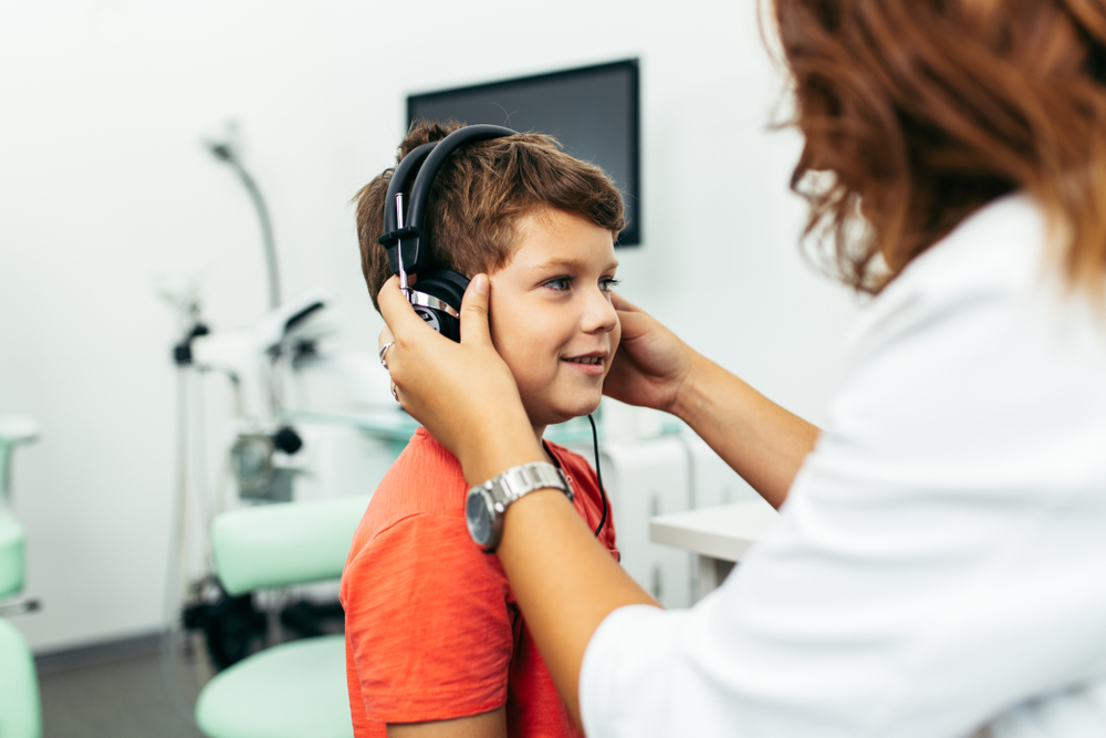 Young boy at medical examination or checkup in otolaryngologist's office