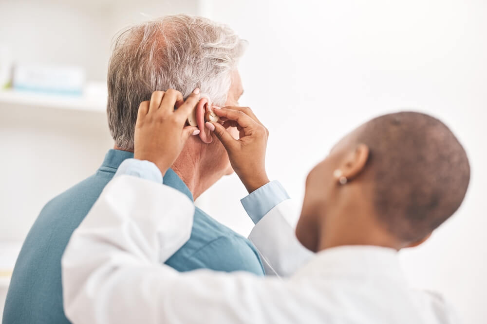 doctor helping patient with hearing test