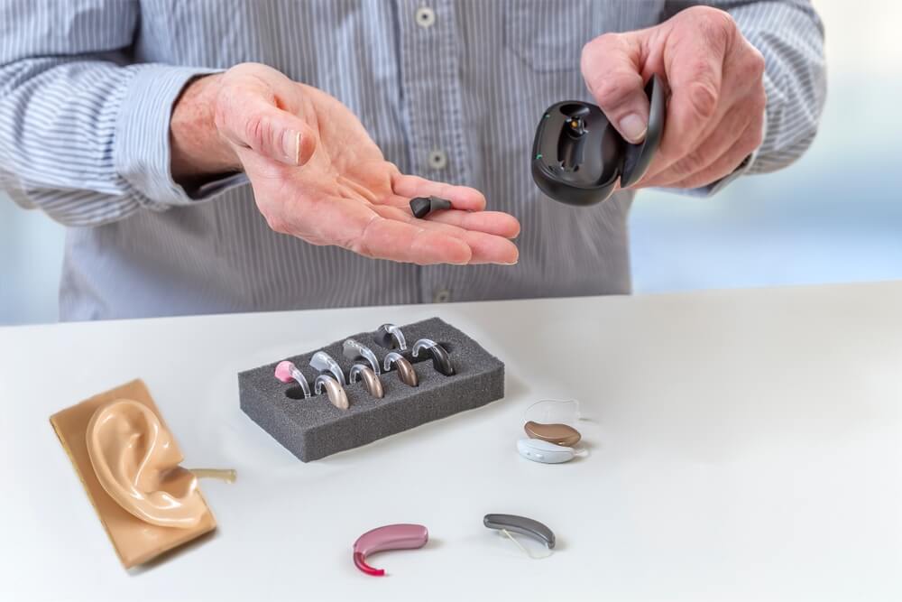 man holding hearing aids