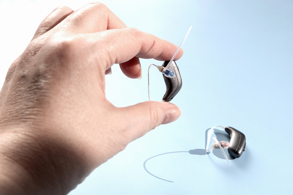 Doctor holding modern hearing aid. Hearing solutions.