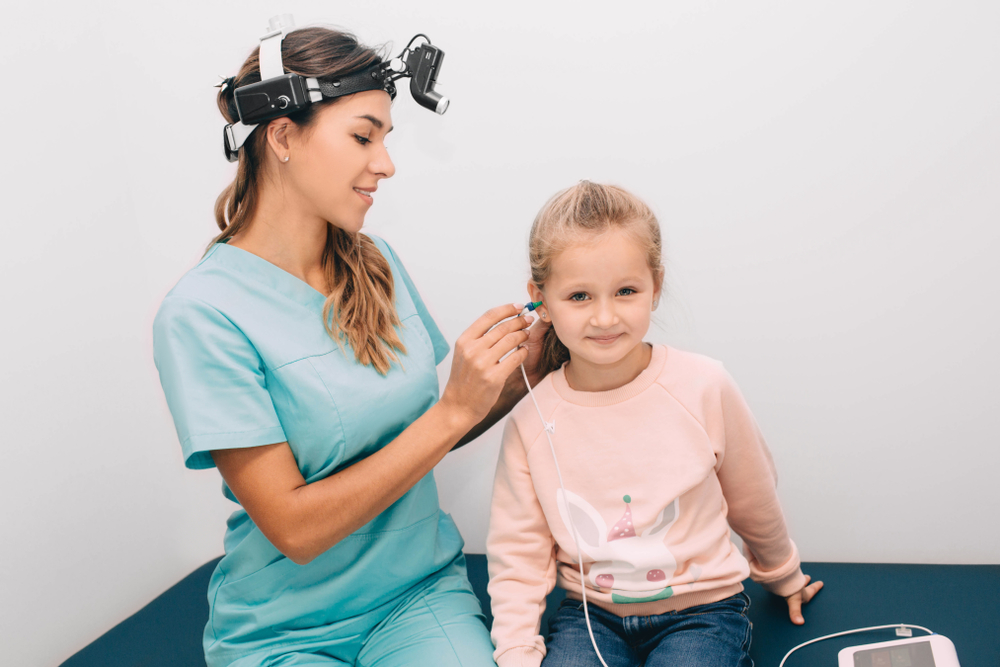 Doctor check a girl's ears. Little girl having hearing test , procedure impedance audiometry