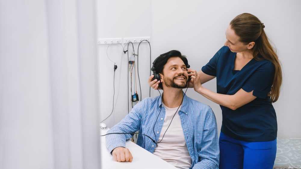 Audiologist conducts a hearing test using headphones in a modern clinic