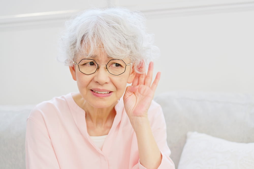 Asian senior woman with hearing loss in the living room