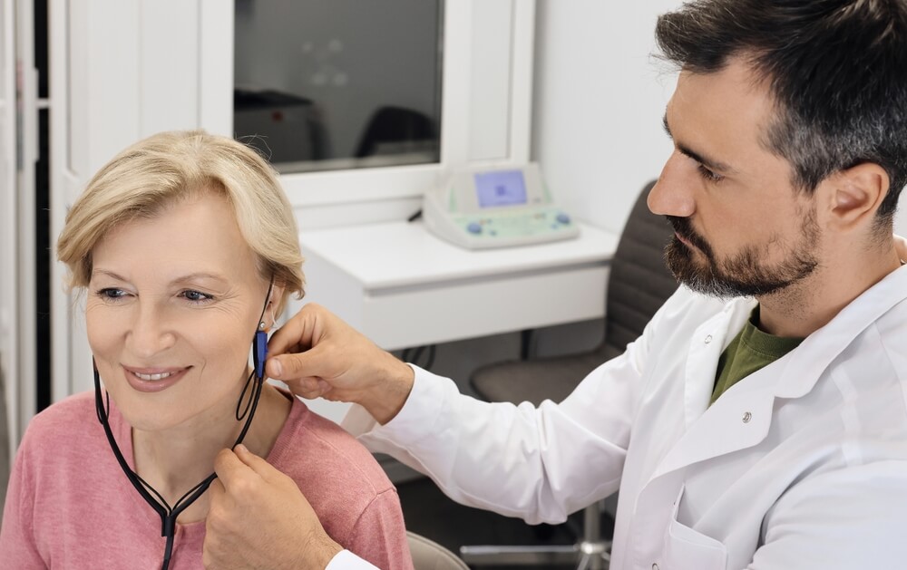 audiologist testing patient's hearing