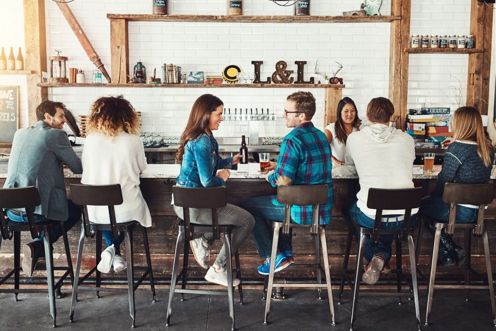 Beer, restaurant and couple at pub with drinks for social gathering, dating and discussion on weekend