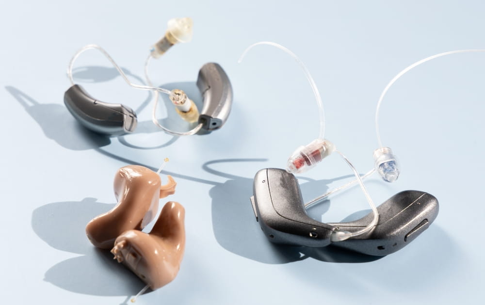 Various modern hearing aids on a blue background. High quality photo