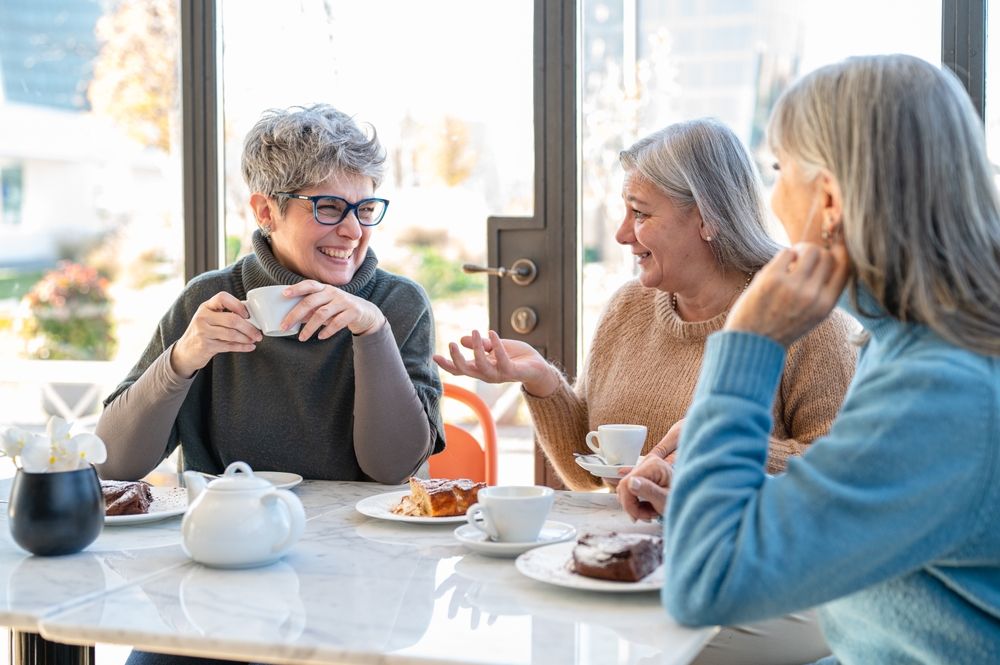 Group of elderly women having fun during breakfast in a cafeteria,