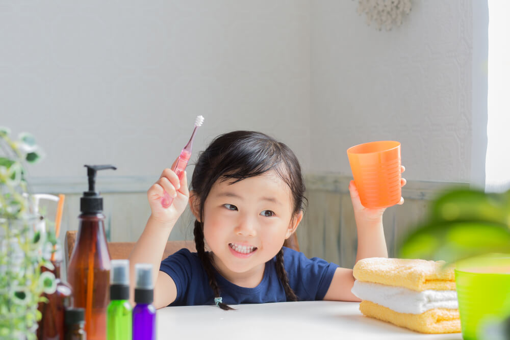 asian little girl brushing teeth