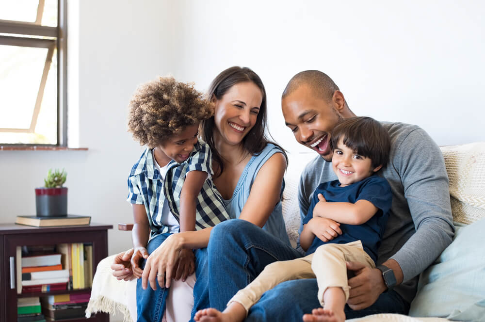 Happy family sitting on sofa laughing together