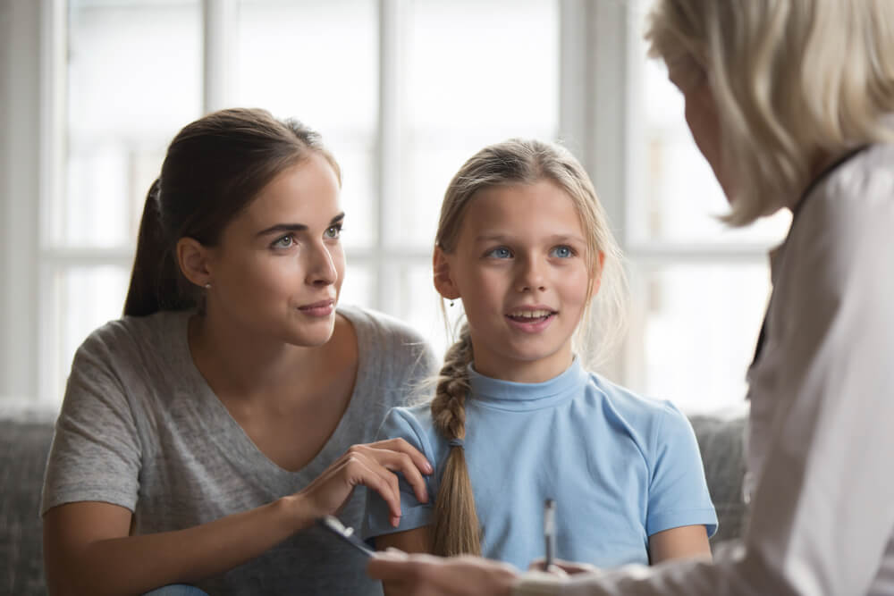 woman pediatrician consult girl with mom