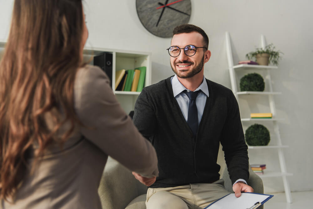 happy psychologist and patient shaking hands