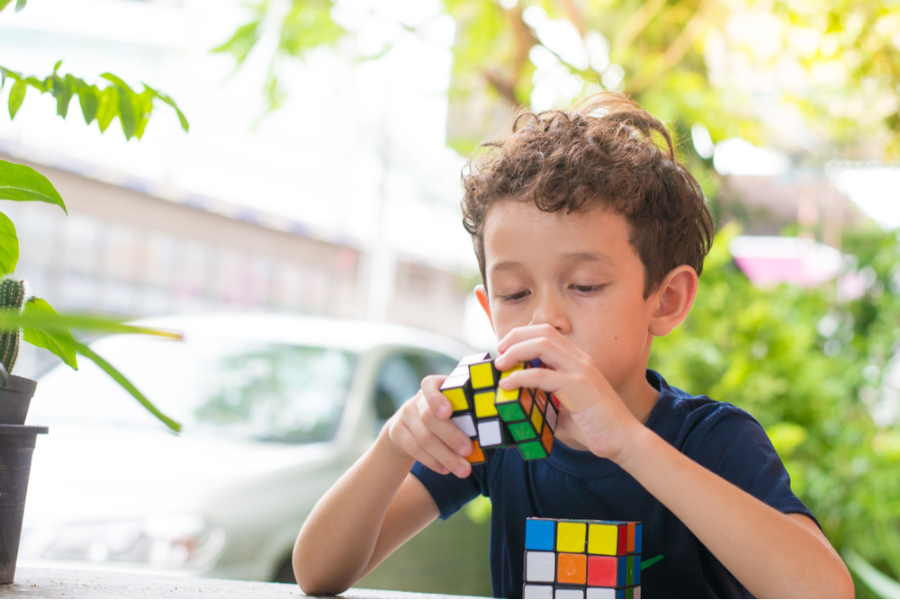 Cute boy plaiyng with the Rubik's Cube