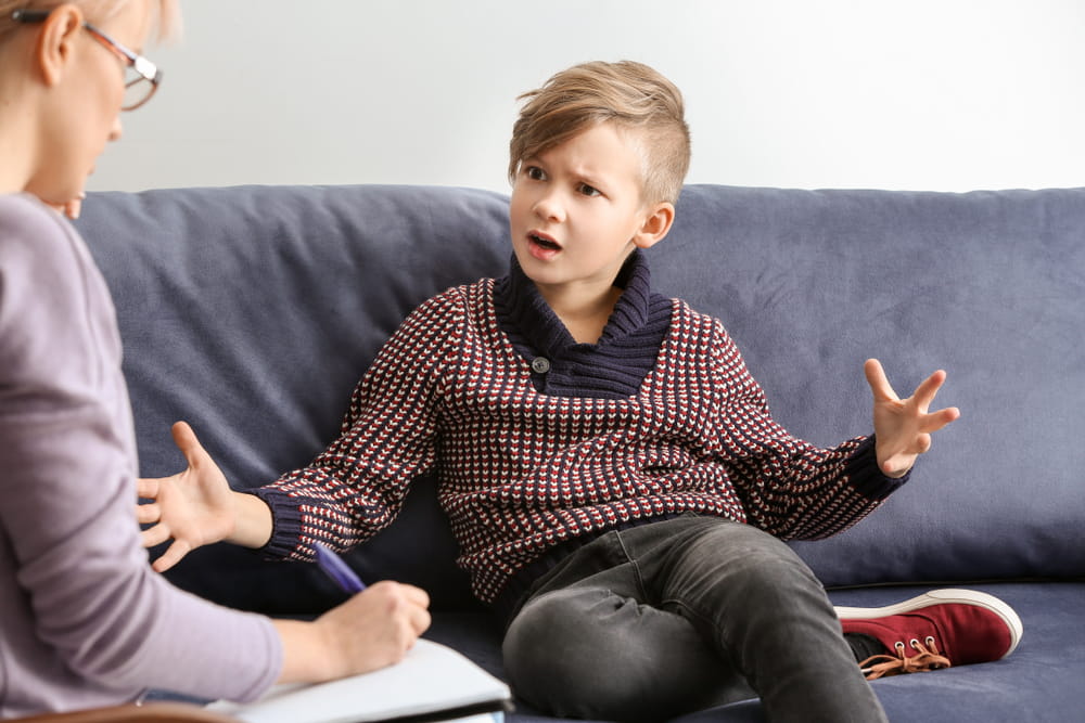 Female psychologist working with little boy in office