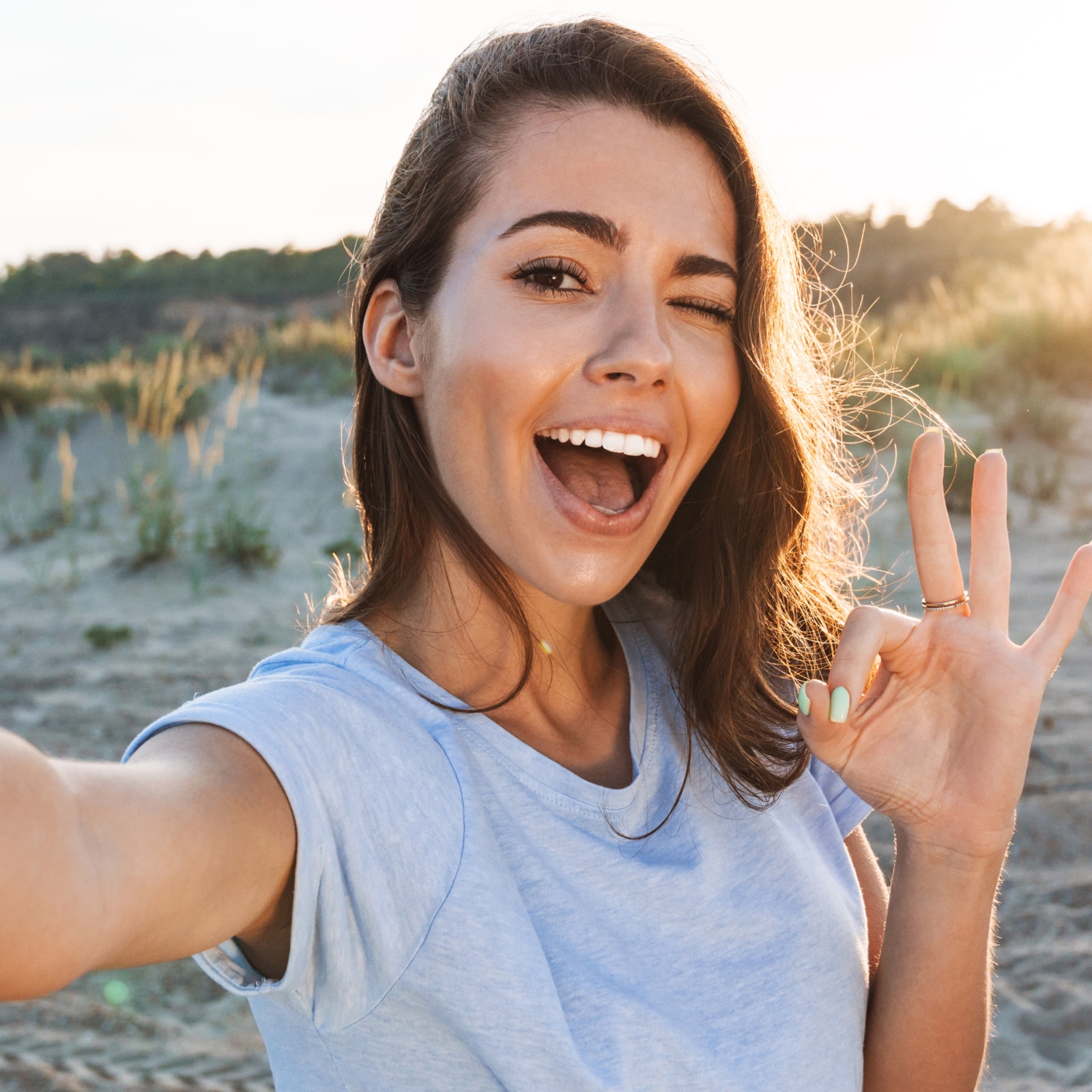 Beautiful cheerful young woman having a good time at the beach