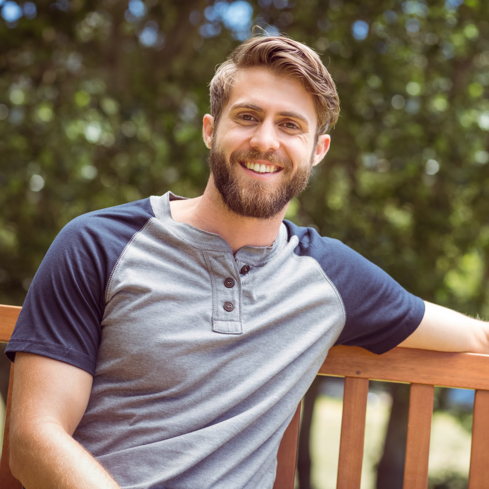 Young man relaxing on park bench