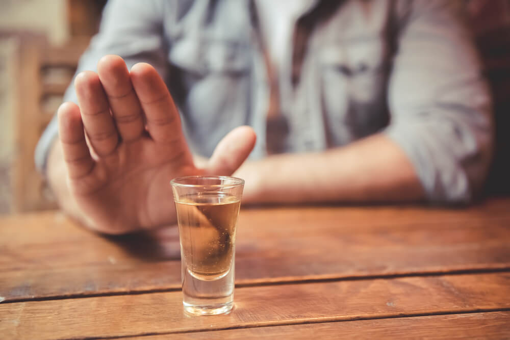 man showing stop gesture and refusing to drink