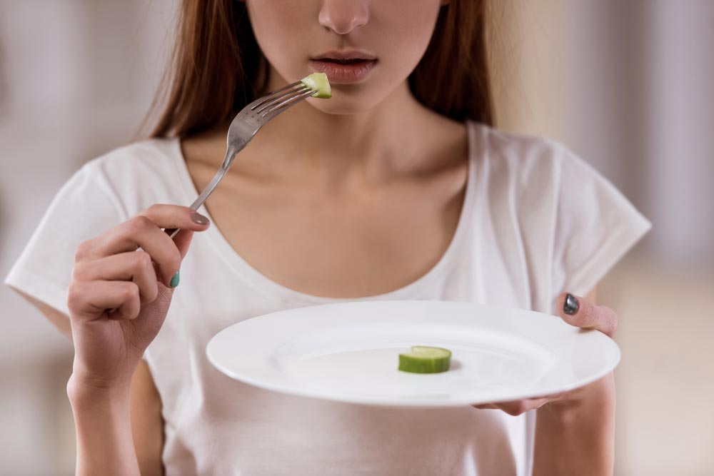 Thin girl with an empty plate standing