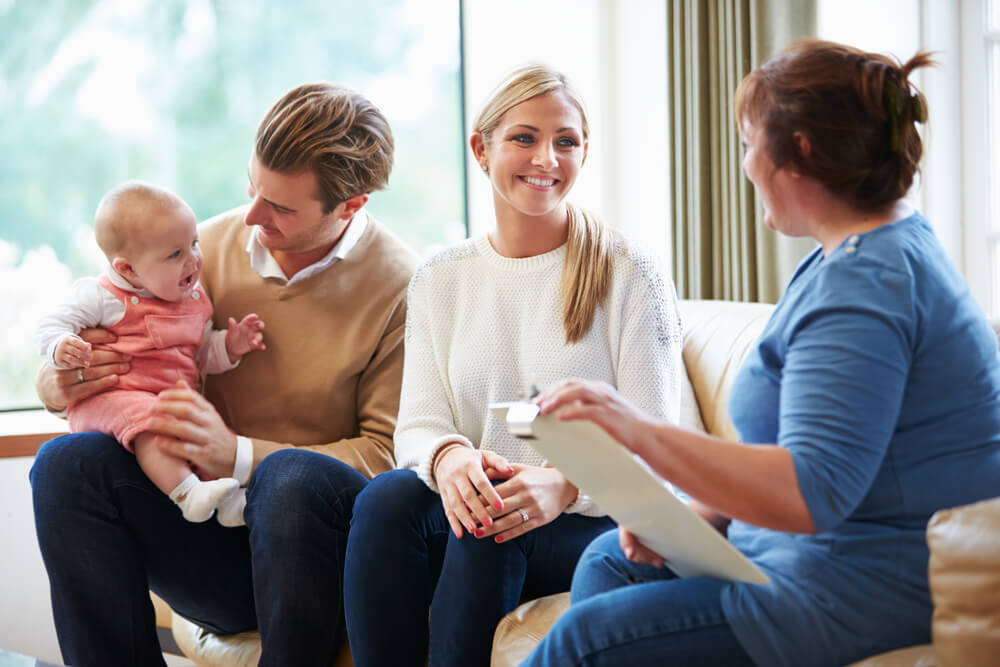 Health Visitor Talking To Family With Young Baby