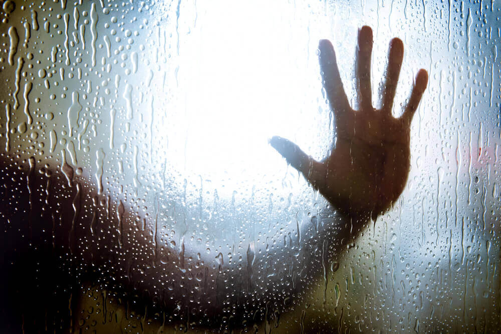 man in the shower holding hands against the glass wall