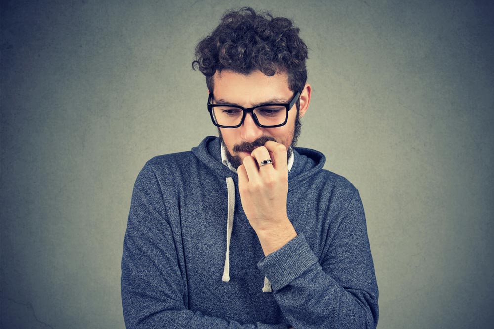 nervous man biting fingernails