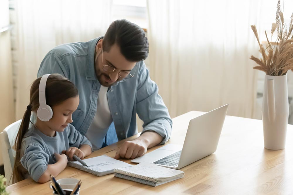 child schoolgirl wearing headphones studying online