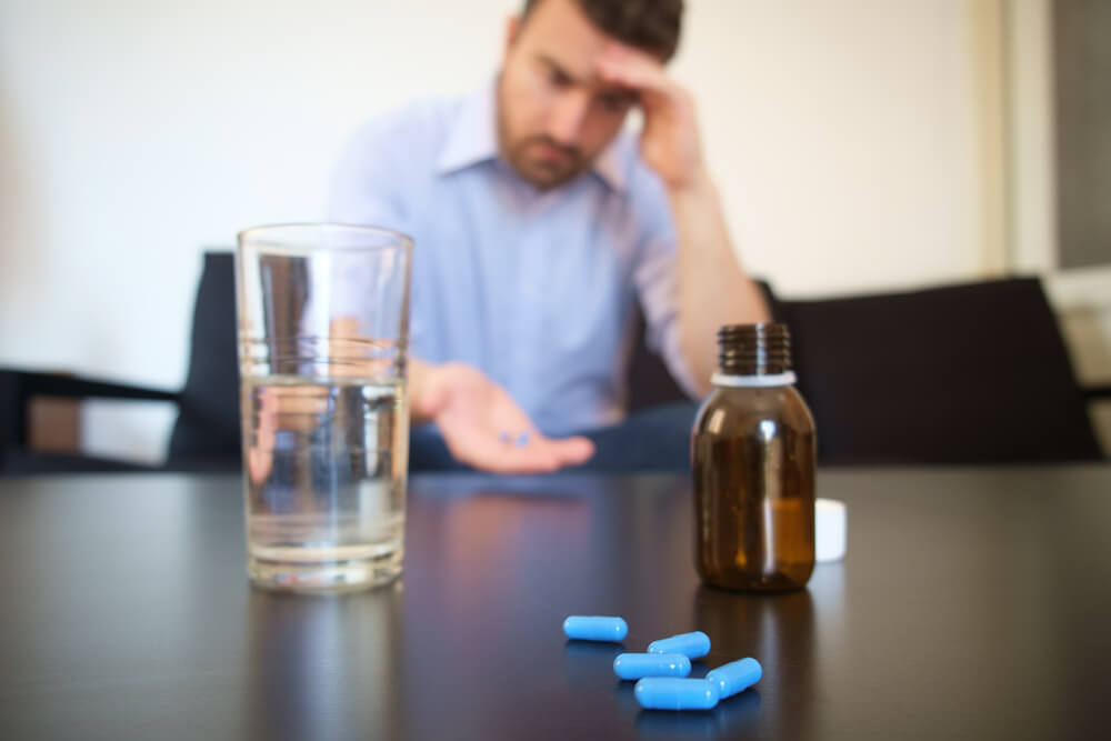 Depressed man taking some pills