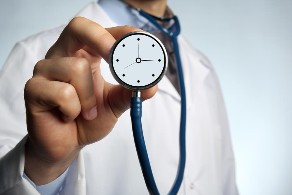 Doctor holding stethoscope with clock