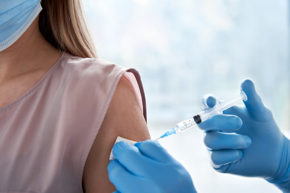 vaccination injection dose in shoulder of female patient