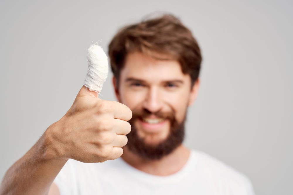 bandaged thumb and happy man