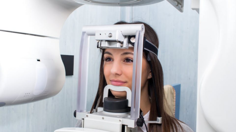girl taking dental tac with cephalometric panorama x-ray
