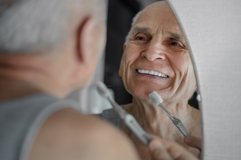 A man brushing new dentures