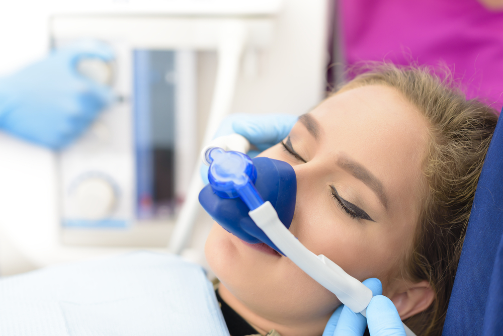 A woman breathing in Nitrous Oxide in a dentists office
