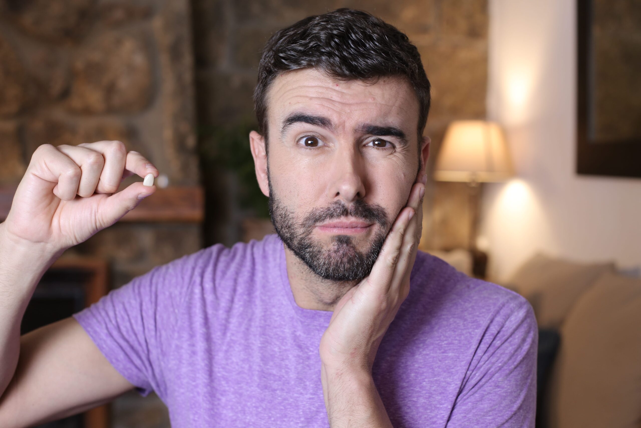 man holding missing tooth in his hand