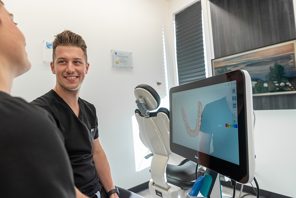 Dr. Woods showing a patient their digital x-rays before placing dental implants in Grand Prairie