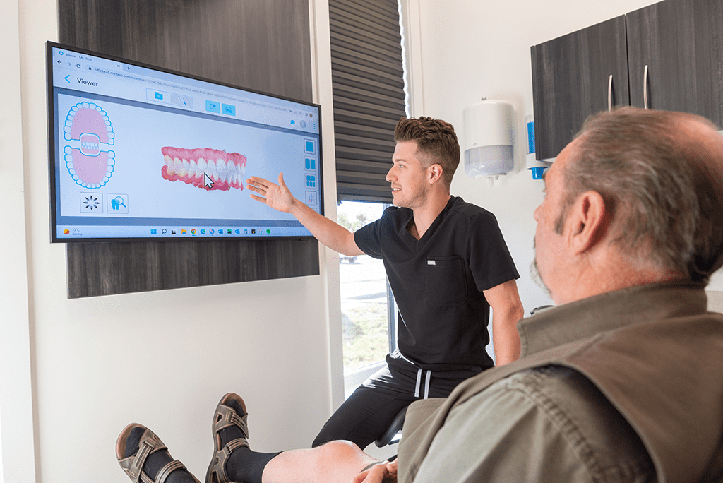 dentist showing a patient all on 4 dental implants