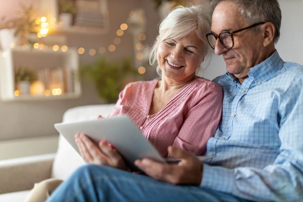 Mature couple using a laptop while relaxing at home