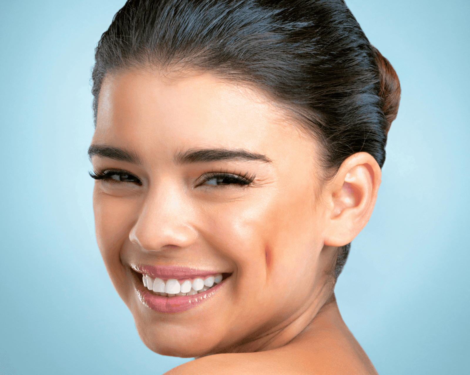 Pretty young woman looking over her shoulder smiling with a beautiful smile