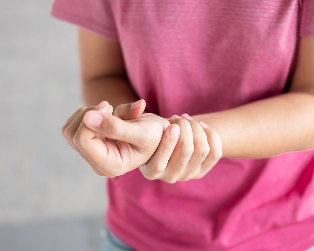 Young woman holding her wrist pain