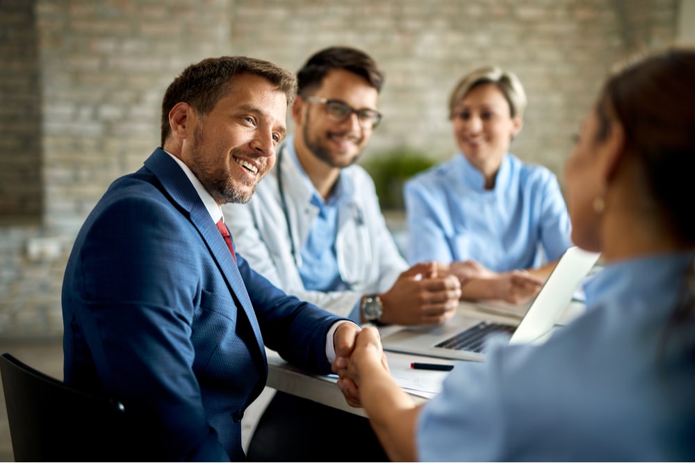 Happy man having a meeting with group of doctors