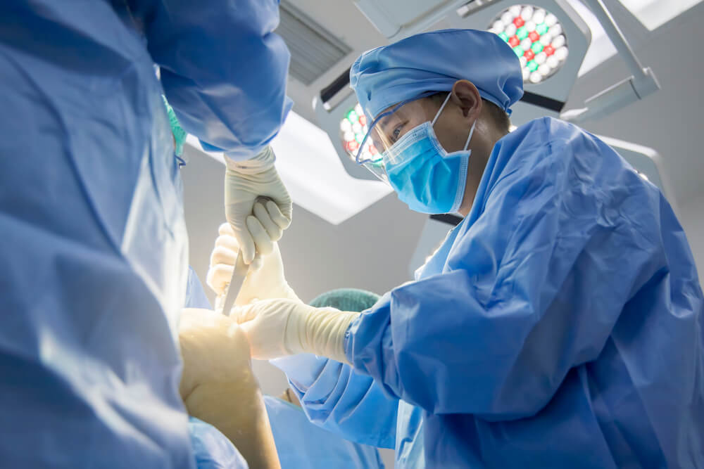 Surgeon perform knee replacement surgery