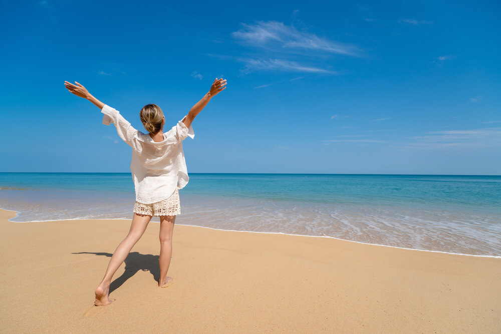 woman enjoying freedom with open hands on sea.