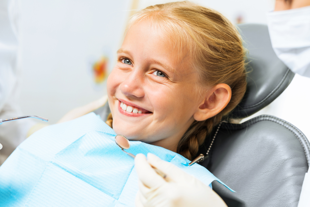 Little cute girl sitting in chair at dentist