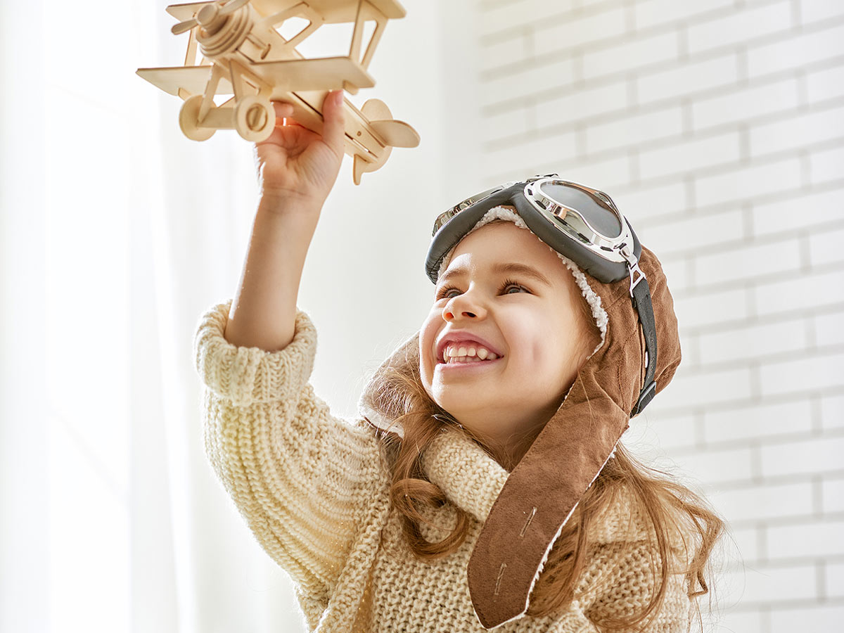 happy child girl playing with toy airplane