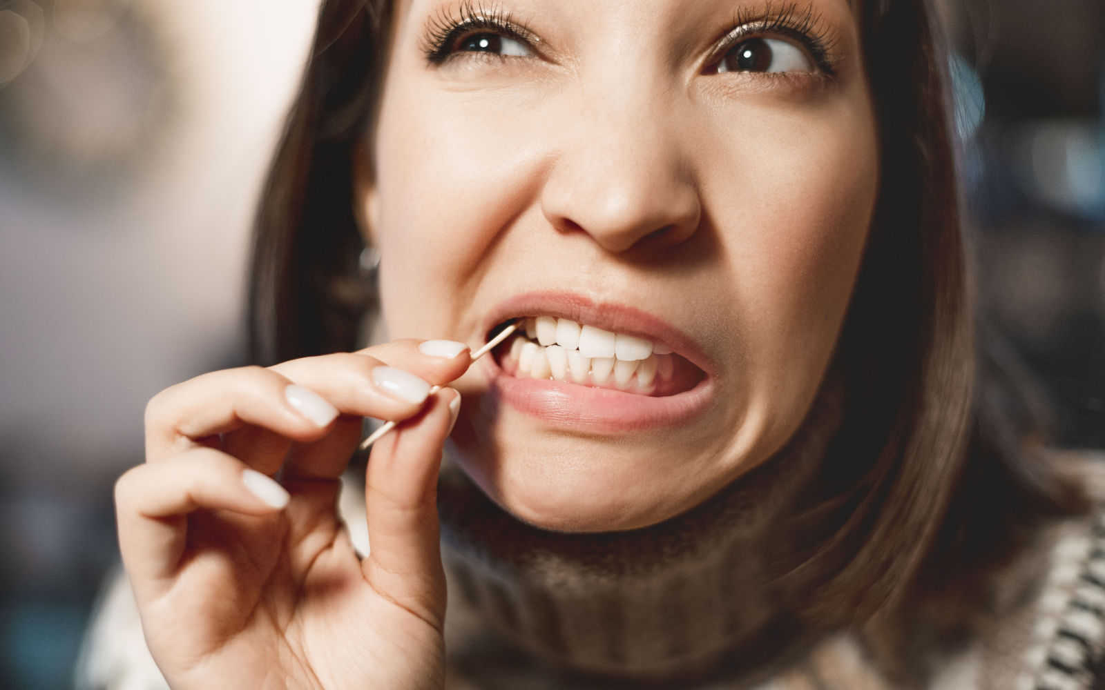 Woman picking teeth with toothpick