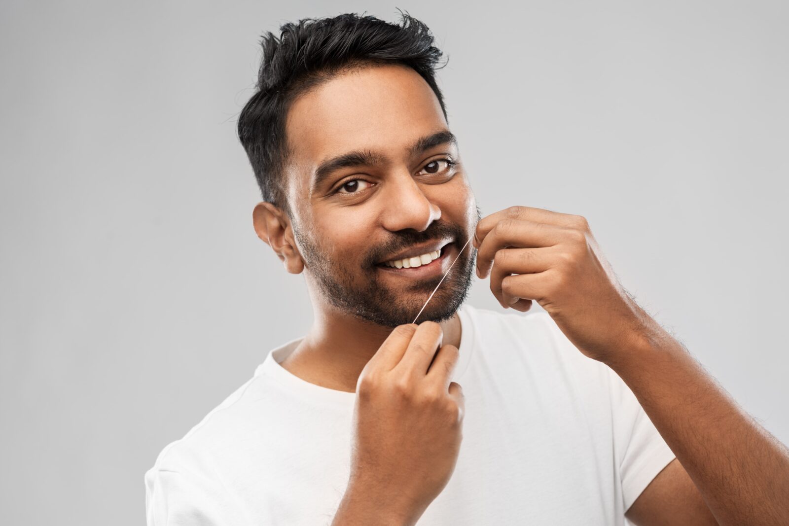 man flossing his teeth